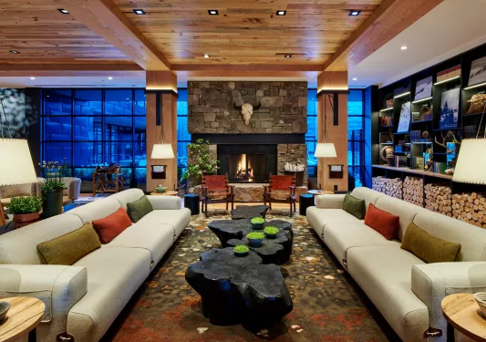 Lobby hotel with couches, black wood coffee tables and a stone fireplace