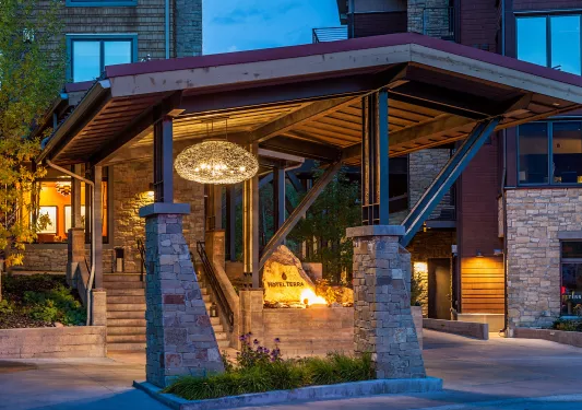 Driveway entrance of hotel building with stone pillars and an illuminated sign