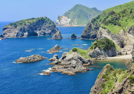 Ocean with large cliffs and boulders to the right