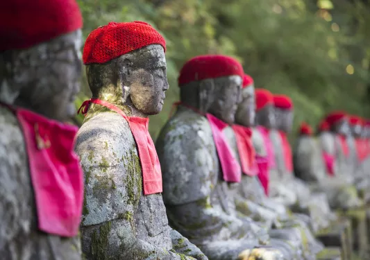 Row of stone statues, with knitted hats and handkerchiefs