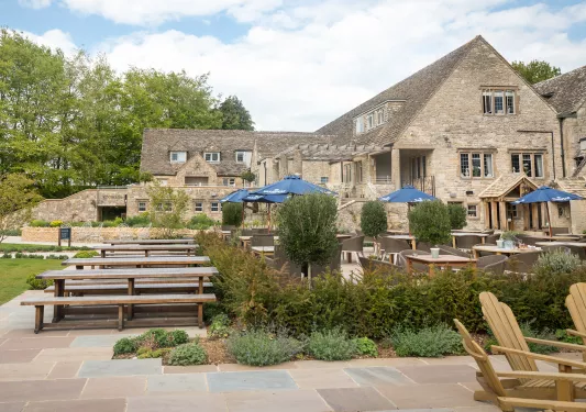 Exterior view of stone and brick building with an outdoor dining patio