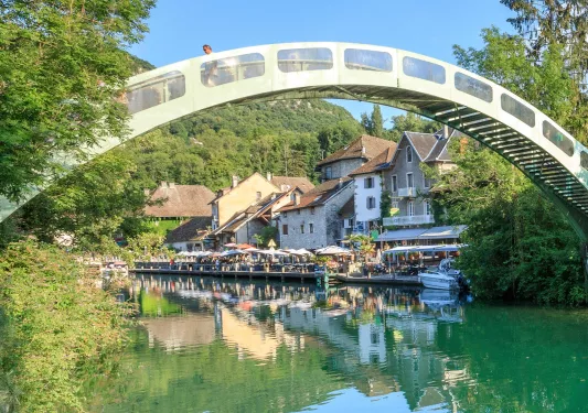 Large arch over a river, with a restaurant in the background
