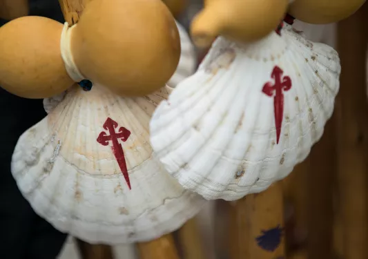 Two white seashells with painted red crosses on them