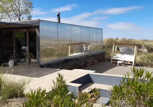 Building with mirror walls in the middle of a valley of plants