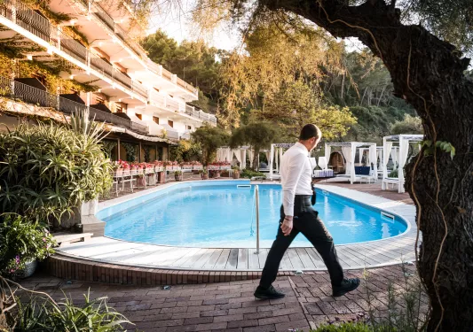 Outdoor pool with a waiter walking around the perimeter