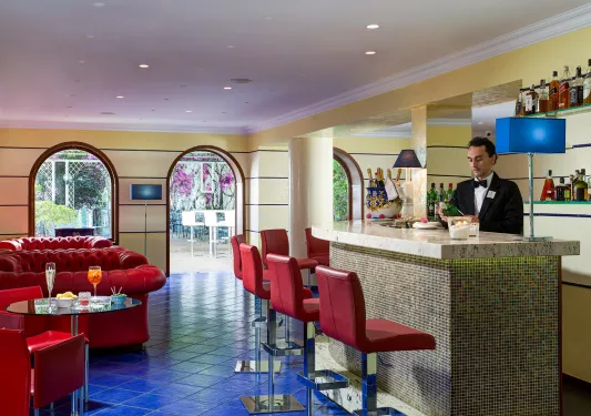 Bar and lounge with a bartender making drinks behind the counter