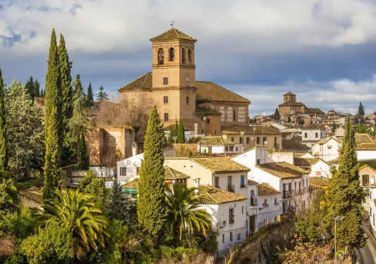 Rustic, white and yellow houses surrounded by tall trees