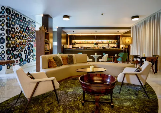 Indoor bar and lounge with circular sofas and a bar in the background