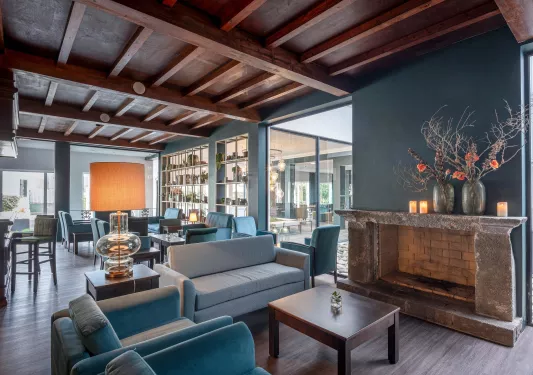 Lobby with cushioned chairs and windows in the background