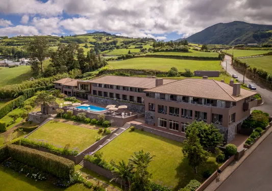 Exterior, sky view of beige hotel building wit large grass fields surrounding the building