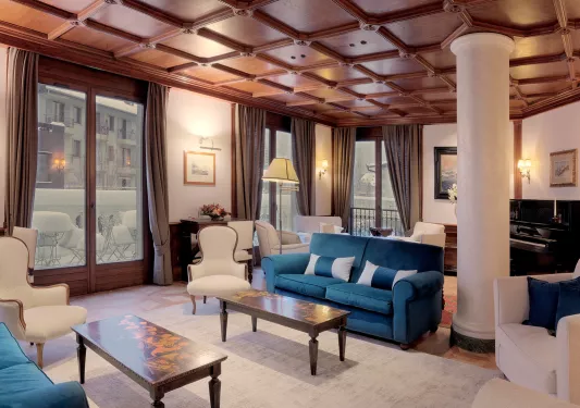Indoor hotel lounge with blue and white cushioned chairs and white pillars