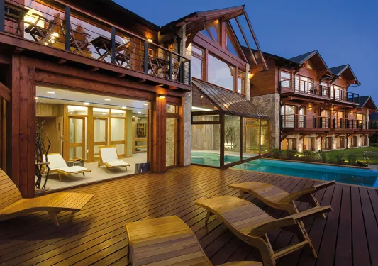 Exterior patio of a wooden cabin with an outdoor pool