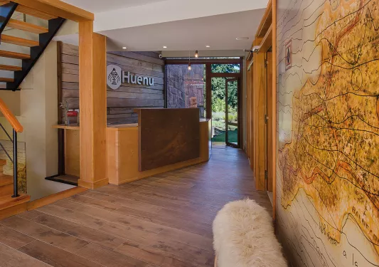 Hotel front desk with a wooden counter and a map on the wall