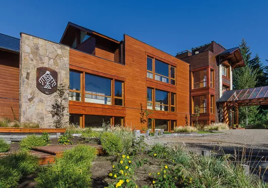 Hotel exterior with wooden wall panels and a grass area in front