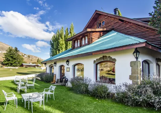 Cabin building with a green roof, and large grass field in front