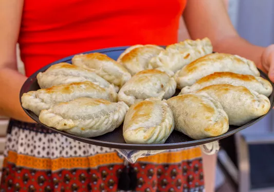 Person holding up a plate full of baked breads
