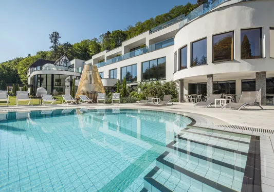 Outdoor pool in front of a long, white hotel building