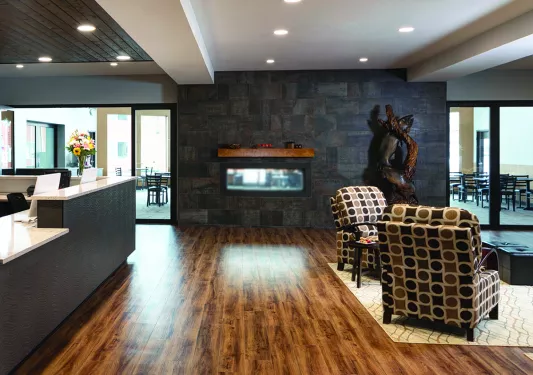 Hotel lobby room with cushioned chairs and a desk check-in counter on the left