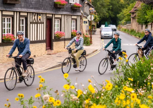 Group of people riding bikes on an empty road in a town