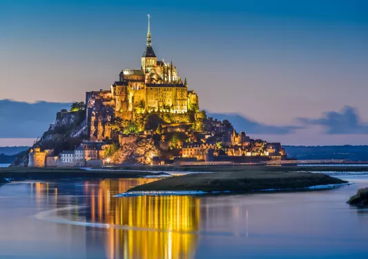 Illuminated building on an island, surrounded by a body of water