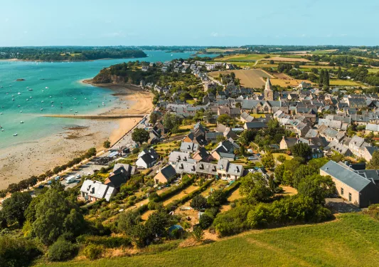 Rustic homes by the oceanside, with large crop valleys in the distance