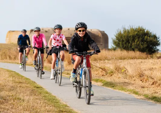 Two parents and two kids riding bikes on a road