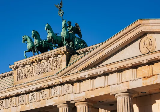 Rustic, stone building with green statues of horses on top