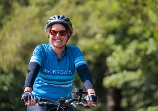 Woman smiling while riding a bike on a road
