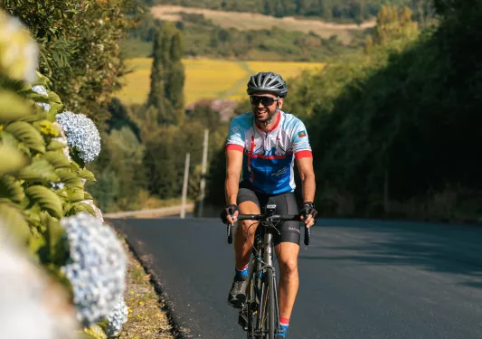 Man smiling while riding a bike on an empty road