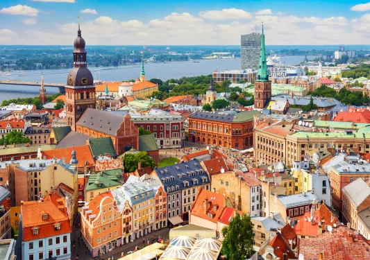 Sky view of a European town with orange apartment building and a large river in the background