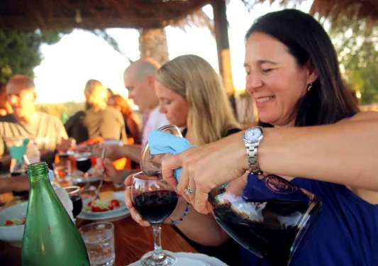 Woman smiling while pouring wine into a glass