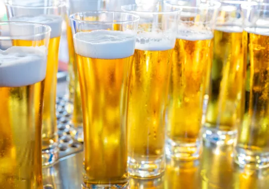 Multiple glasses of beer on a steel countertop