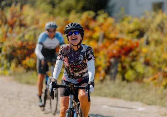 Woman smiling and laughing, while riding her bike on a road