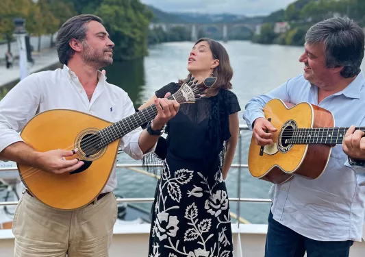 Woman singing while two men are playing guitar