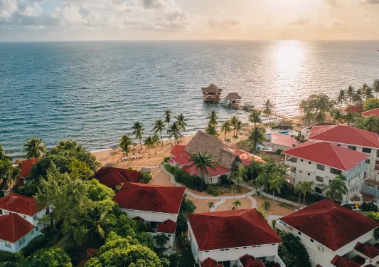 Sky view of red and white hotel building with the beach in view