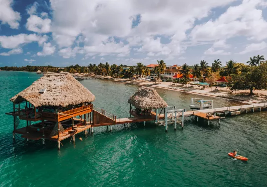 Beach with a long bridge leading to a straw hut