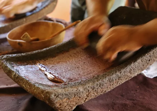 Person using a flat mortar and pestle