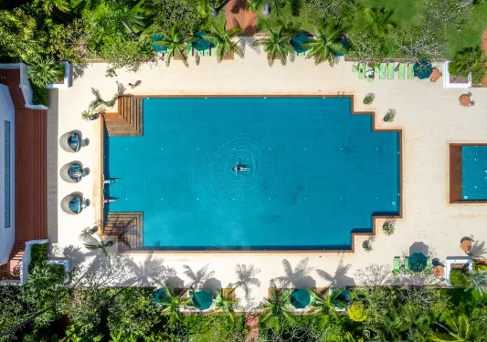 Sky view of outdoor pool with someone swimming
