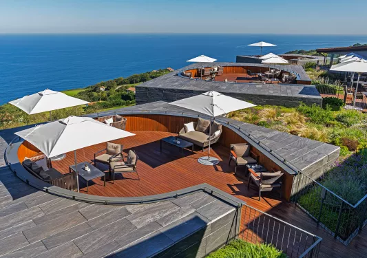 Outdoor patio with cushioned chairs and white umbrellas