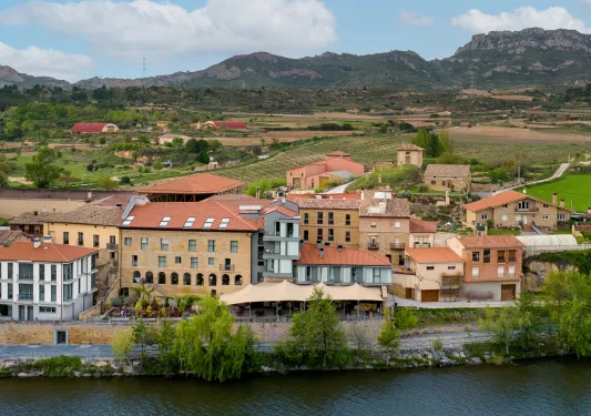 Exterior, sky view of a red and orange hotel complex, with crop fields in the distance