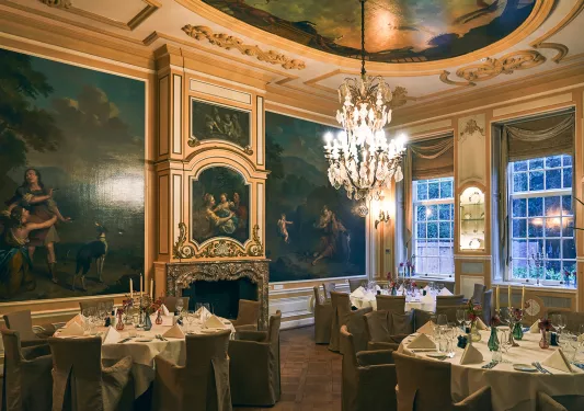 Dining hall with large circular tables and paintings on the wall