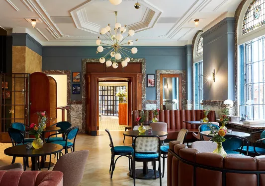 Hotel lounge and seating area with cushioned sofas and chairs, in front of circular tables