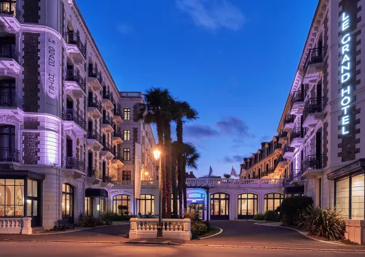 Exterior view of large hotel complex at night, illuminated by warm lights
