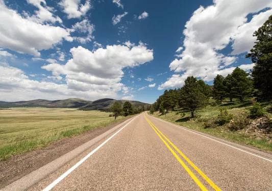 Long road in the middle of a large grass valley