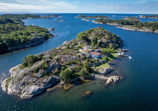 Island surrounded by water, with a house in the center