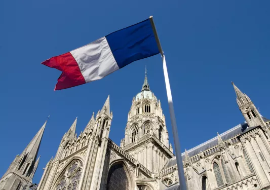 French flag in front of a large cathedral building