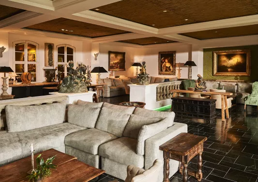 Hotel lobby and seating area, with cushioned sofas, with copper statues around the room