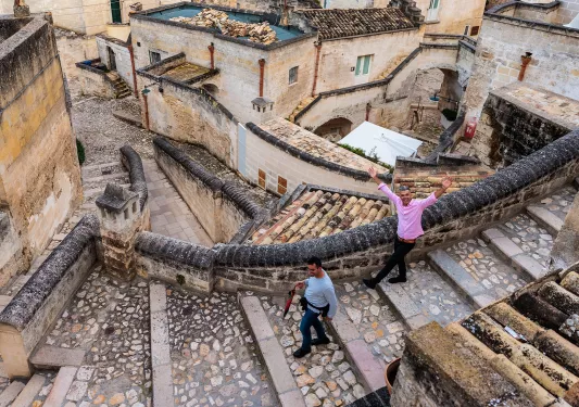 Two men walking through a flight of stone stairs in a town