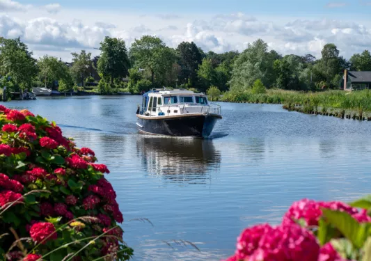 Boat on a lake with large trees surrounding the lake