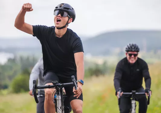 Man riding a bike, yelling with his fist in the air